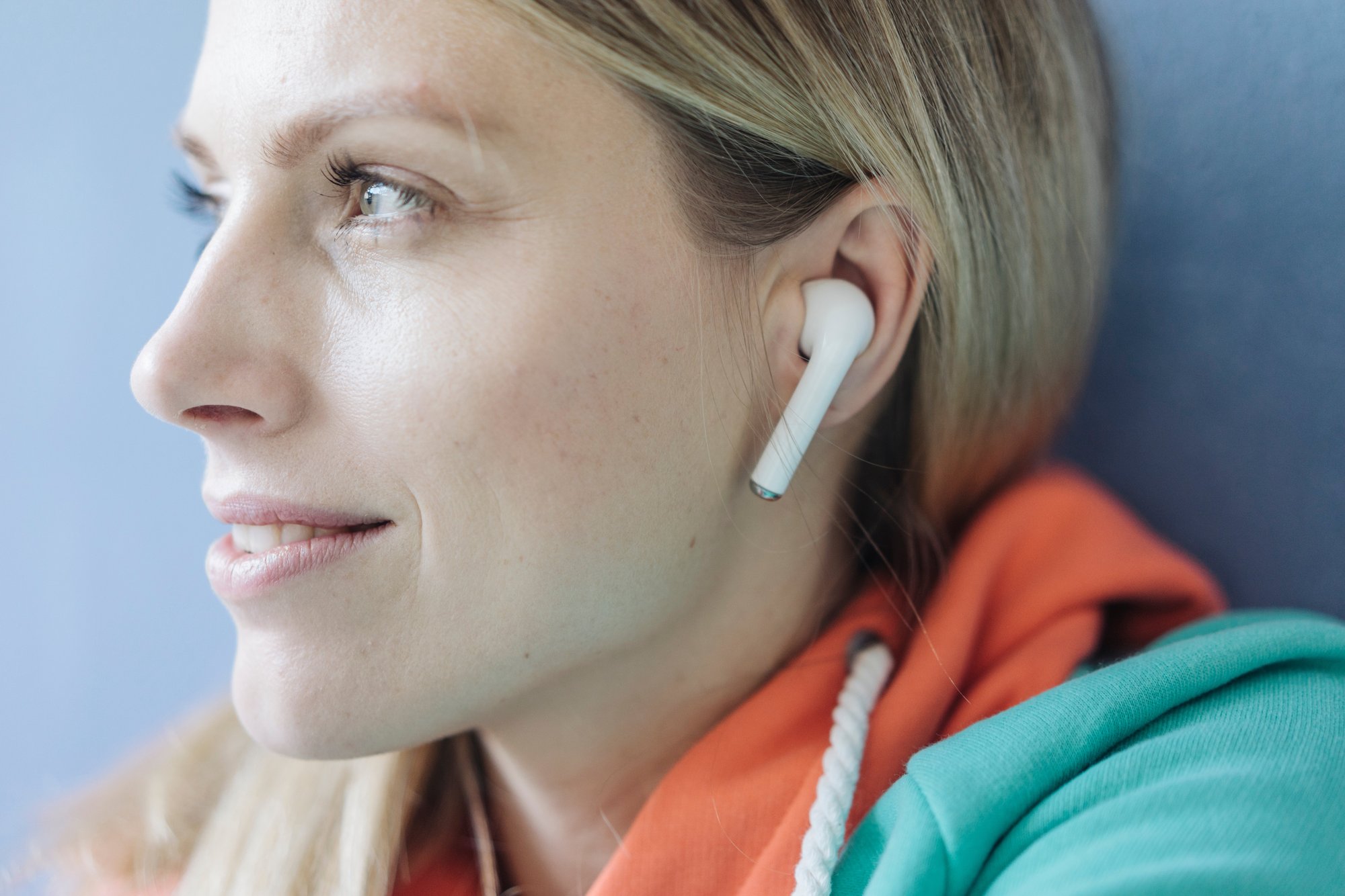 Close-up of a person wearing a white wireless earbud