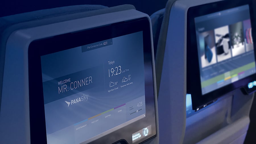 Close-up of airplane seatback touch screens displaying flight information and entertainment options