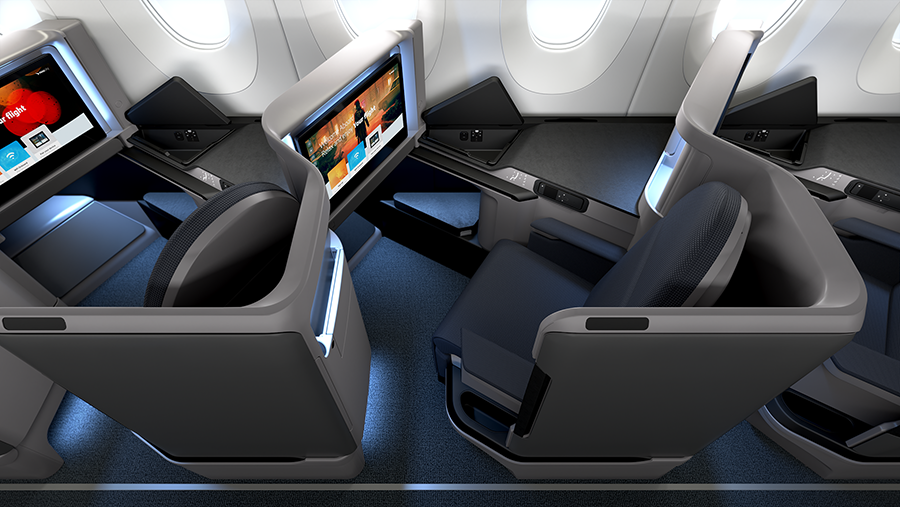 Business class airplane seats with individual screens and dark gray seating pods